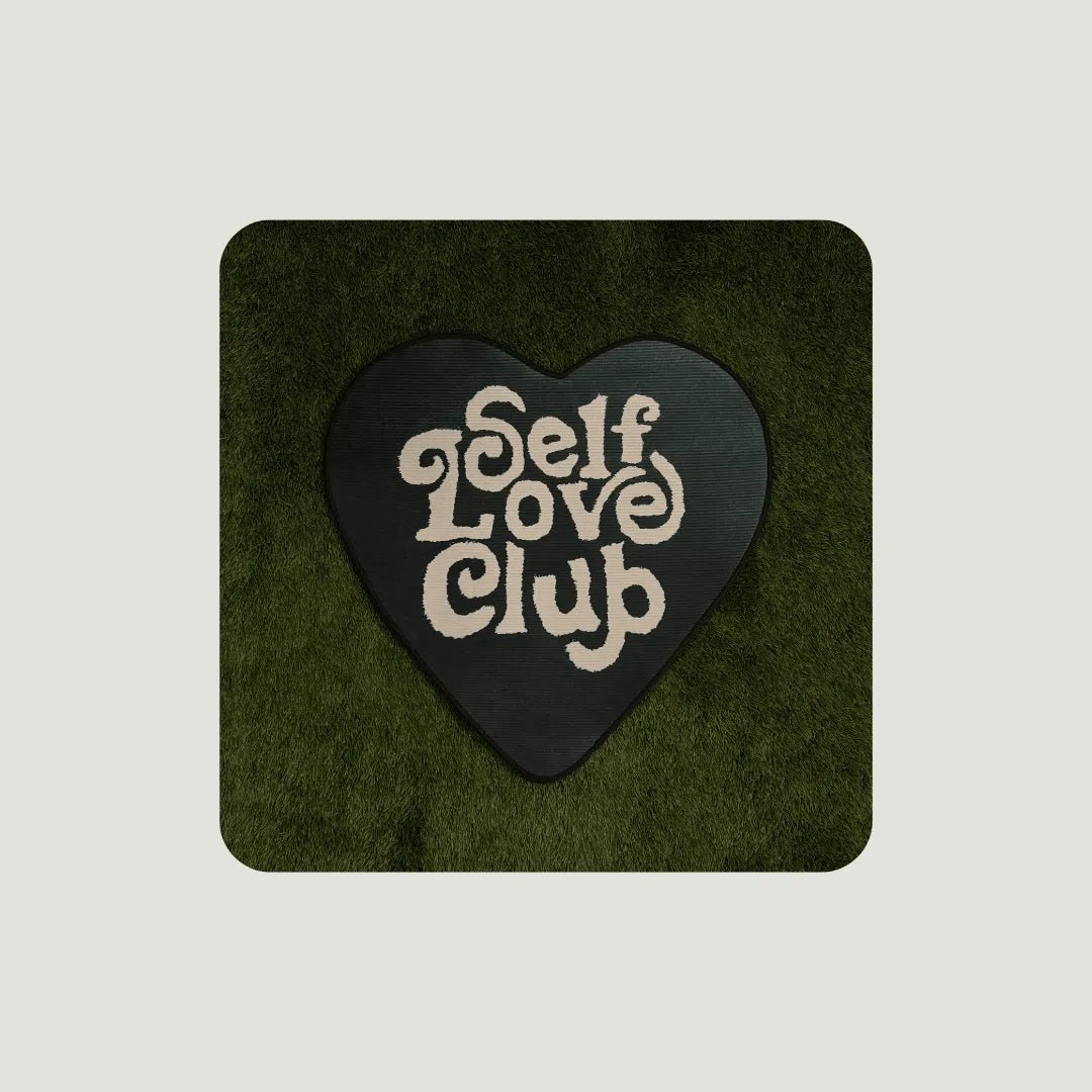 Self Love Club Rugs in various sizes arranged on turf to show scale and vibrant green design in natural light.