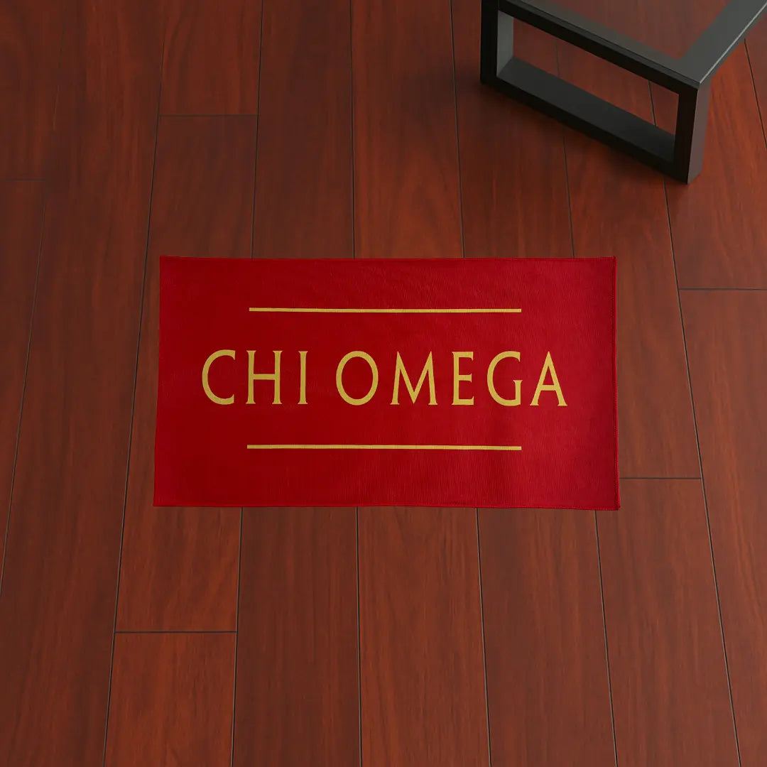 Custom Rug – Chi Omega Red & Yellow custom rug by Sirenicate Rugs, prominently displayed on a vibrant dark hardwood floor background.