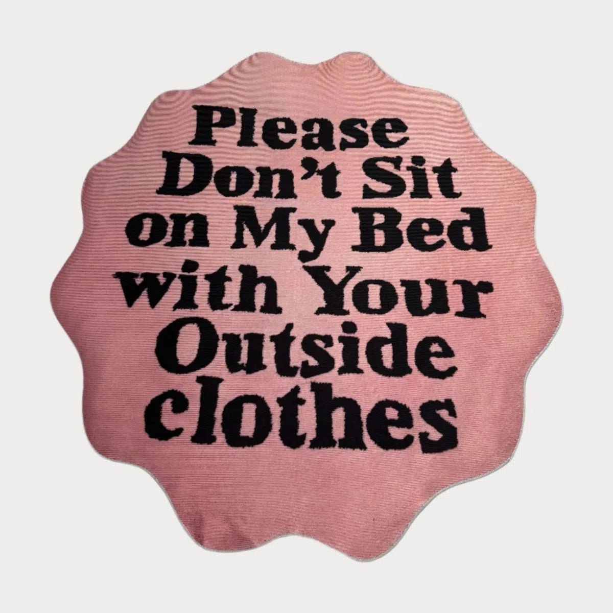 Custom “Don’t Sit on My Bed” Rug in pink with circular black text, displayed flat on a white surface.