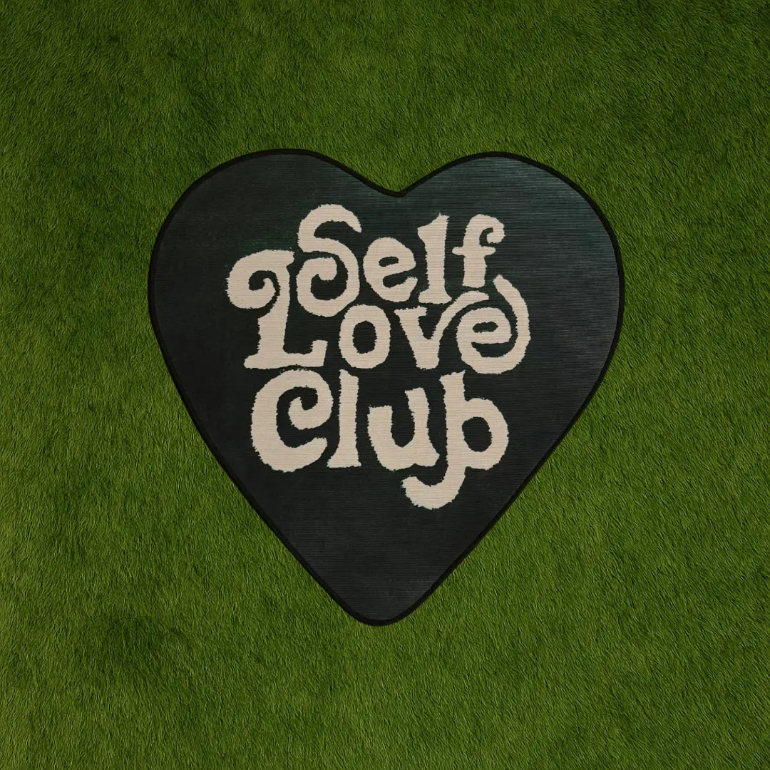Custom Rug - Self Love Club Green Heart Design custom rug by Sirenicate Rugs, prominently displayed on a vibrant dark green turf background.