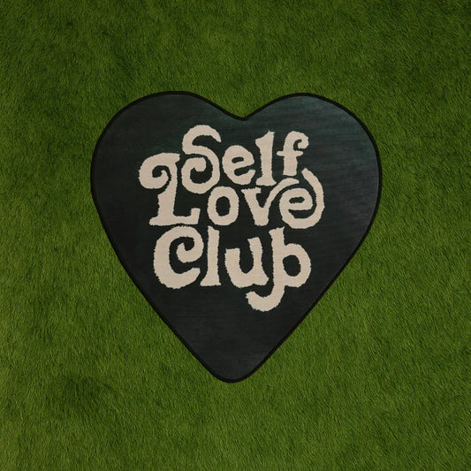 Custom Rug - Self Love Club Green Heart Design custom rug by Sirenicate Rugs, prominently displayed on a vibrant dark green turf background.